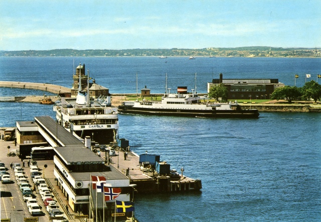Helsingborgs havn i 2. halvdel af 1960erne eller i begyndelsen af 1970erne. To Helsingør-Helsingborg færger: DSBs DAN på vej ud, og SFLs CAROLA ved kaj. Foto: Postkort