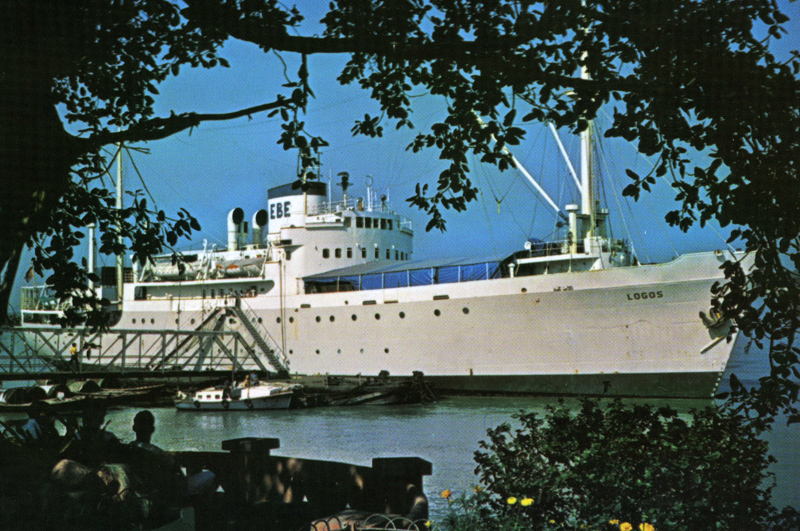 Biblioteksskibet LOGOS, der her ses på et ikke umiddelbart kendt sted, blev bygget på Helsingør Skibsværft i 1949 som UMANAK til Den Kongelige Grønlandske Handel. Skibet var et kombineret fragt- og passagerskib, der sejlede mellem Danmark og Grønland indtil begyndelsen af 1969. I 1970 solgtes skibet til Singapore for anvendelse som missions-,  biblioteks- og uddannelsesskib. Skibet strandede og totalhaverede i dårligt vejr i Beaglekanalen på Ildlandet i januar 1988.