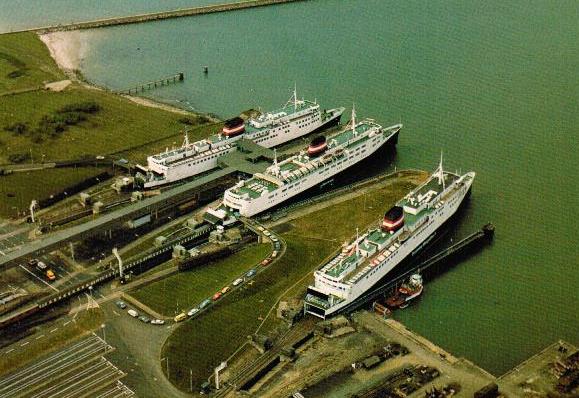 3 danske færger i en tysk havn. Luftfoto af Puttgarden færgehavn i juni 1982 med DSB-færgerne. Fra venstre: PRINS HENRIK, DANMARK og DRONNING MARGRETHE II. Foto: Postkort