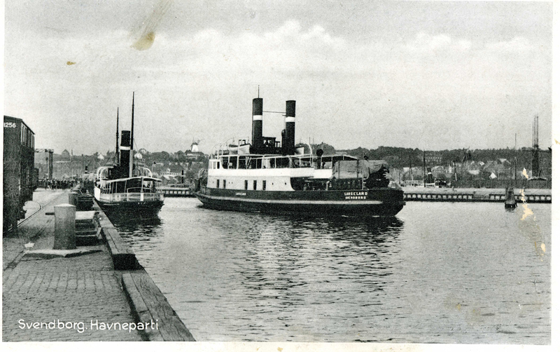 Svendborg Havn mellem 1926 og 1930 med to skibe tilhørende Sydfyenske Dampskibsselskab nærmest. T.v.  damppassagerskibet SIF og i midten dampjernbanefærgen LANGELAND. Foto: Postkort
